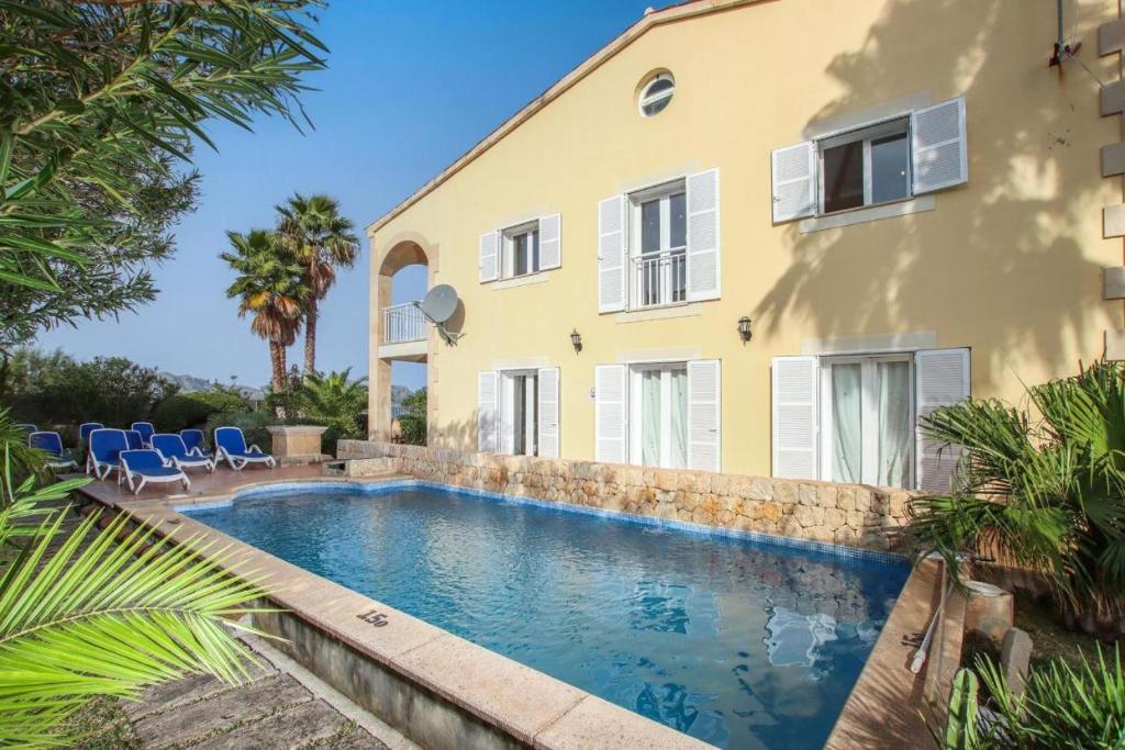 una piscina di fronte a una casa di Villa Amoros a Alcudia