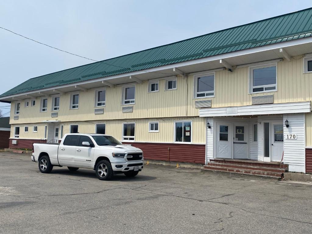 a white truck parked in front of a building at Alpha Inn in Wawa