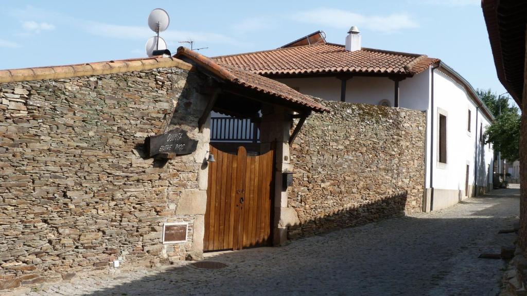 a stone building with a wooden door on a street at Quinta Entre Rios in Mirandela