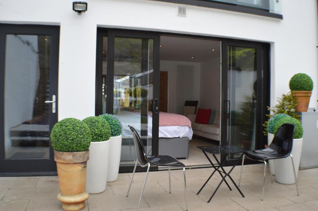 a patio with chairs and potted plants and a bedroom at Pier39Portrush Adult Only in Portrush