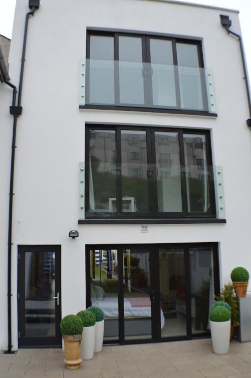an office building with glass doors and potted plants at Pier39Portrush Adult Only in Portrush