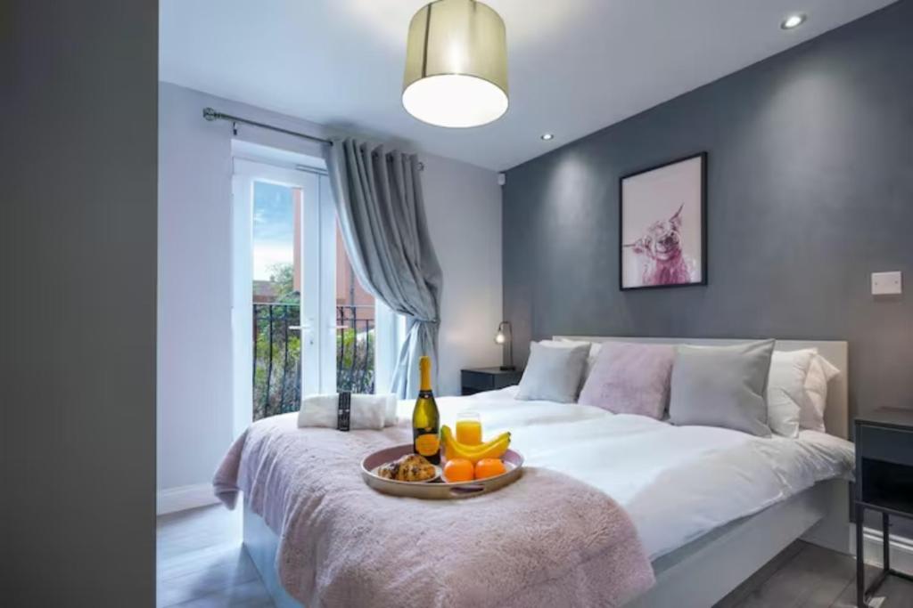 a bedroom with a bed with a tray of fruit on it at Stylish Apartment - Close to the City Centre - Free Parking, Fast Wi-Fi and Smart TV with Netflix by Yoko Property in Aylesbury