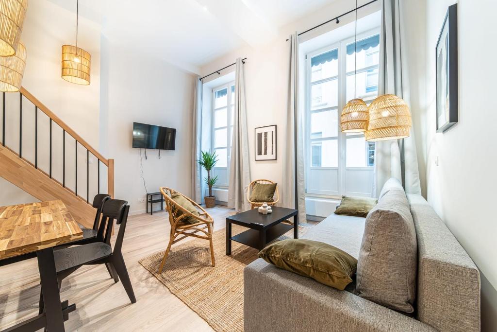 a living room with a couch and a table at Les Suites de l'Opéra appartement Nina 6 pers in Lyon