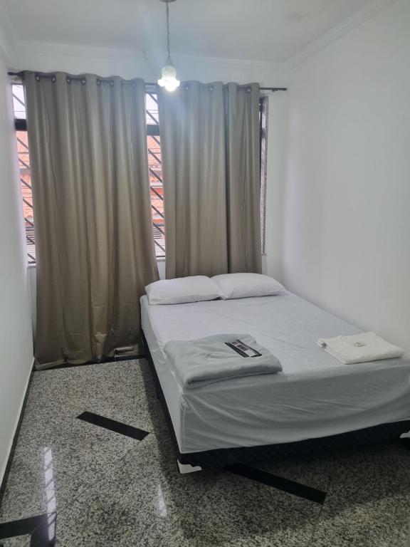 Bett in einem Zimmer mit Fenster in der Unterkunft Hostel Anprado in Guarulhos