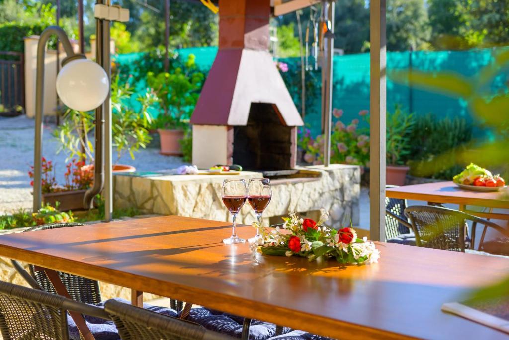 a table with two glasses of wine and a fireplace at Apartments Silvana 74 in Pula