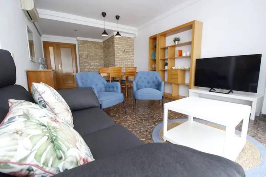 a living room with a couch and a flat screen tv at Playa Malvarrosa House in Valencia