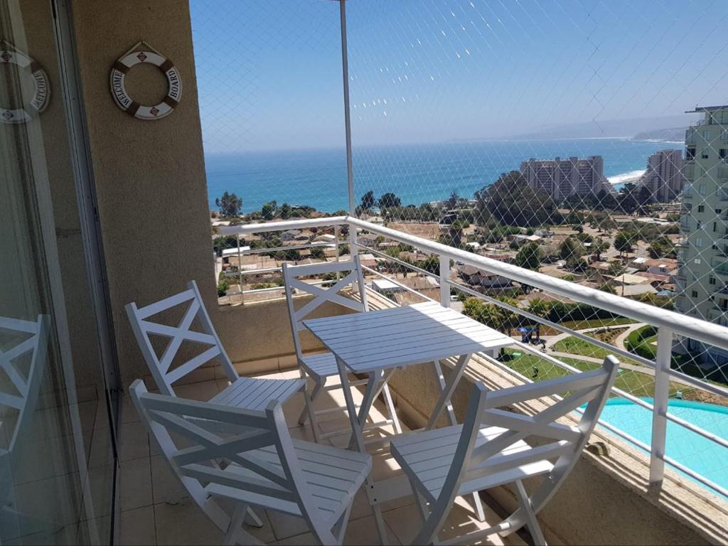 einen Balkon mit einem Tisch, Stühlen und Meerblick in der Unterkunft Espectacular Depto Laguna Vista Algarrobo (3D2B) in Algarrobo