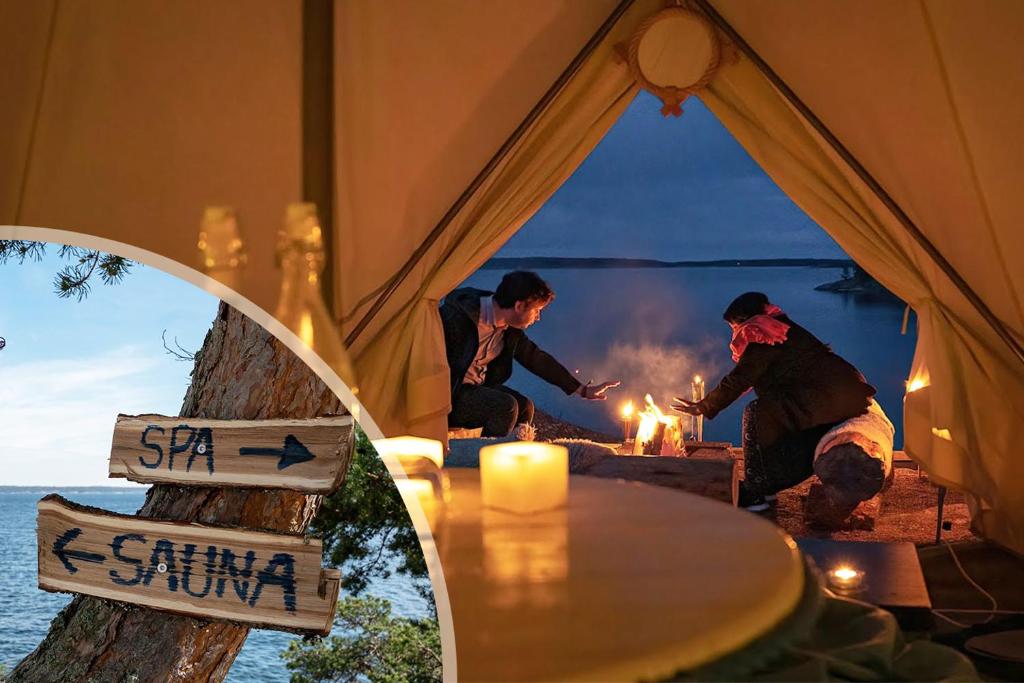 grupa ludzi stojących wokół ognia w namiocie w obiekcie Stockholm Archipelago Retreat w mieście Ingmarsö