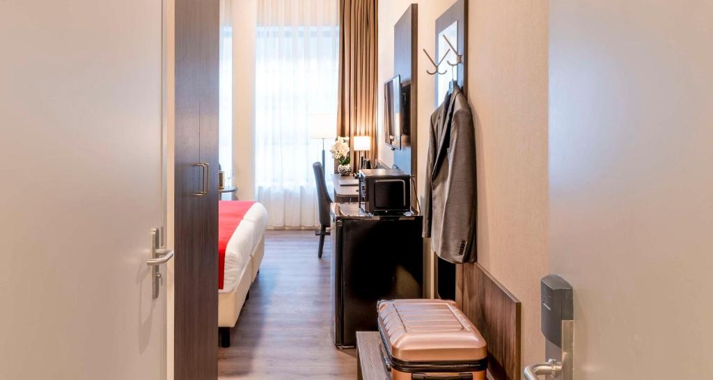 Pokój z sypialnią z łóżkiem i stołem w obiekcie Best Western Plus Plaza Den Haag City Center w Hadze