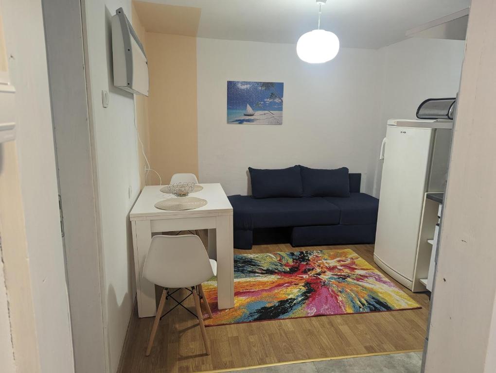 uma sala de estar com uma mesa e um sofá azul em Oaza em Banja Luka