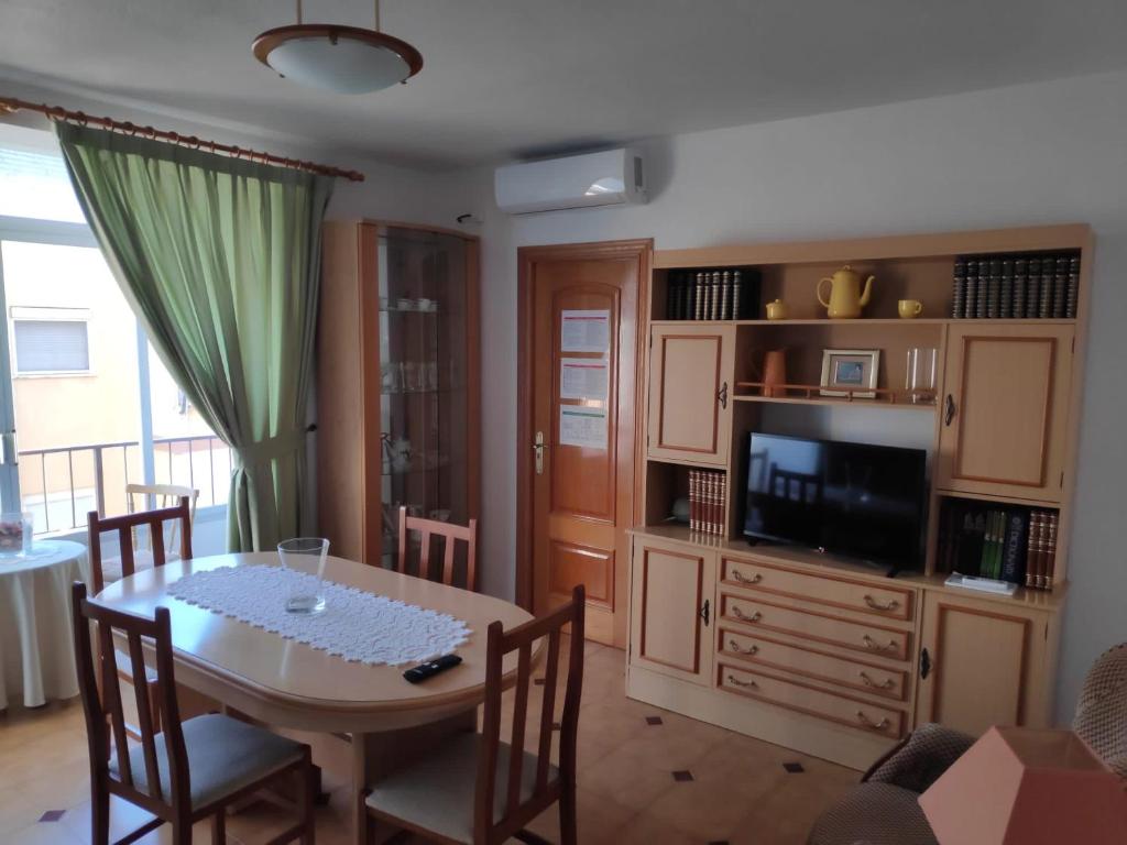 a dining room with a table and a television at Luna Home in Villajoyosa