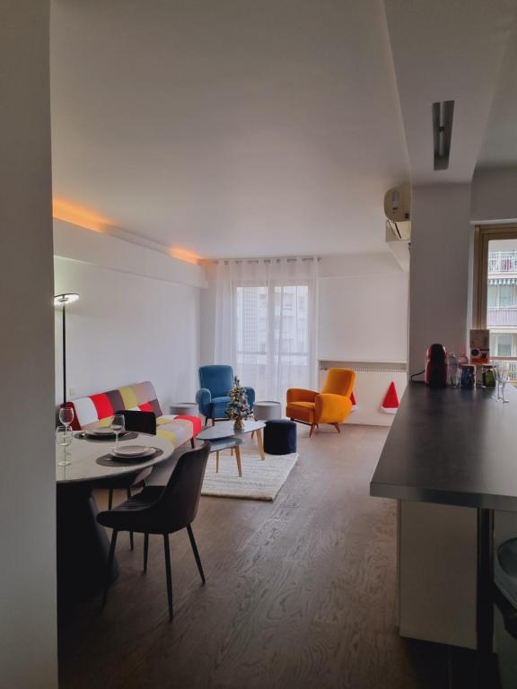 een woonkamer met een bank en een tafel en stoelen bij Appart'Chic in Parijs