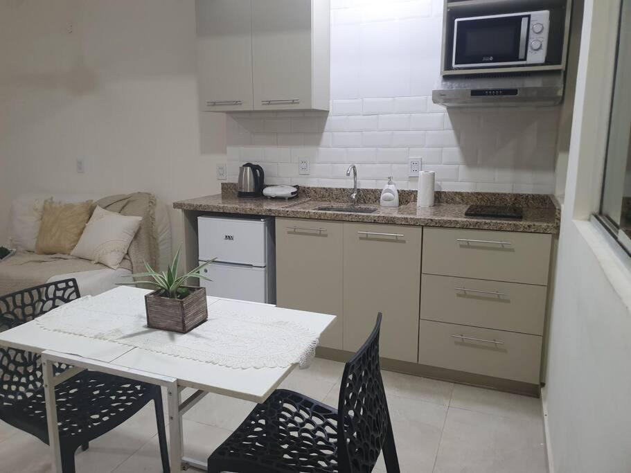 een kleine keuken met een tafel en een tafel en stoelen bij Departamento Nuevo, Asunción in Asuncion