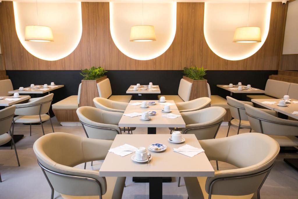 een restaurant met tafels, stoelen en verlichting bij Regency Park Hotel in Rio de Janeiro