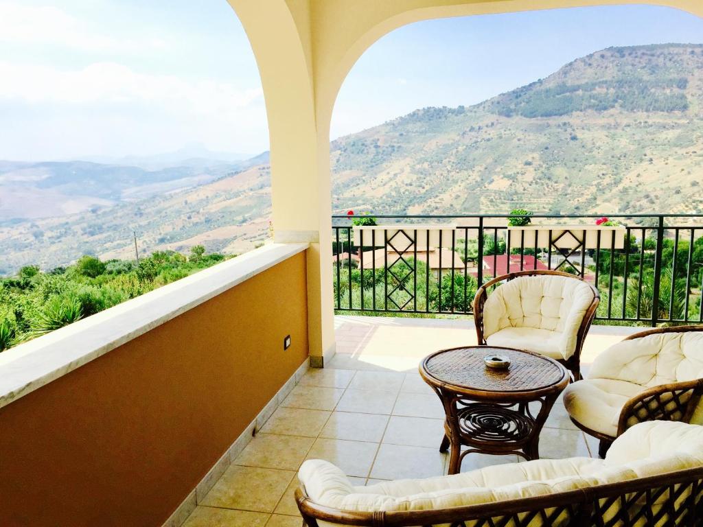 balcone con sedie, tavolo e vista di Villa della Mimosa ad Alia