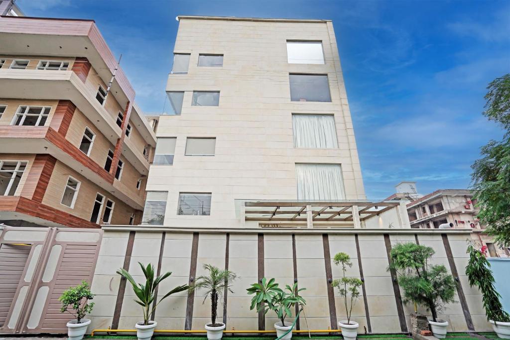 um edifício alto com palmeiras em frente em Diamond Admire Hotel & Banquets by MMD em Noida