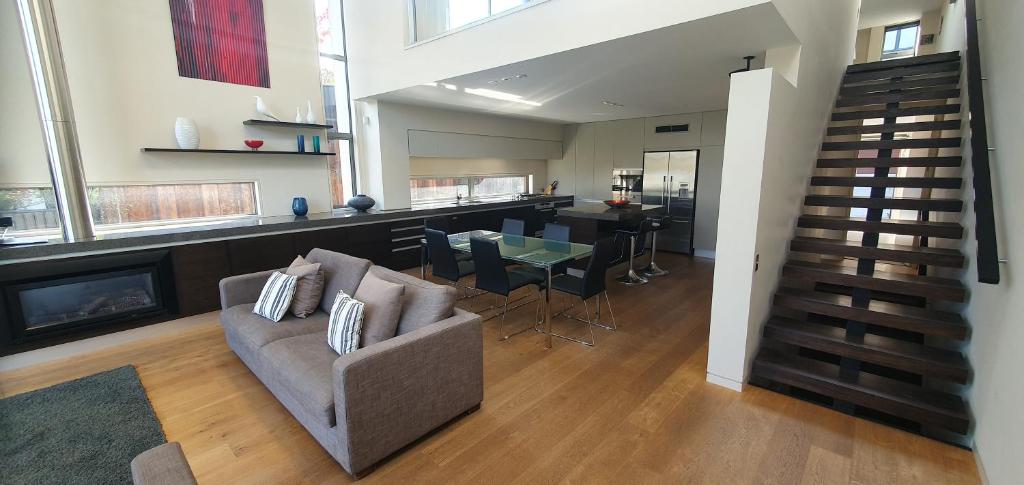 a living room with a couch and a table and a staircase at Lakeshore Springs Apartments in Wanaka