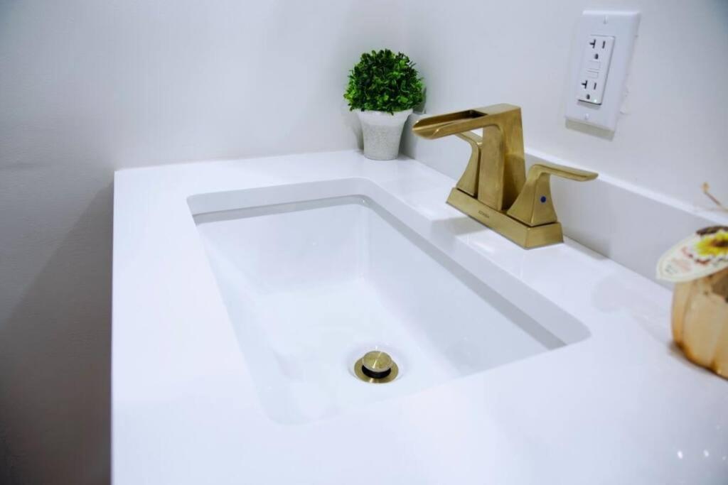 un lavandino in bagno con rubinetto d'oro di Unique, Modern and Lovely Space! a East Providence
