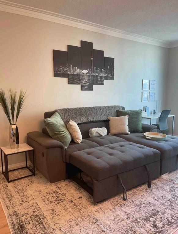 ein Wohnzimmer mit einem braunen Sofa in einem Zimmer in der Unterkunft 1BR Condo DWTN Toronto - free Parking, Gym & Pool in Toronto