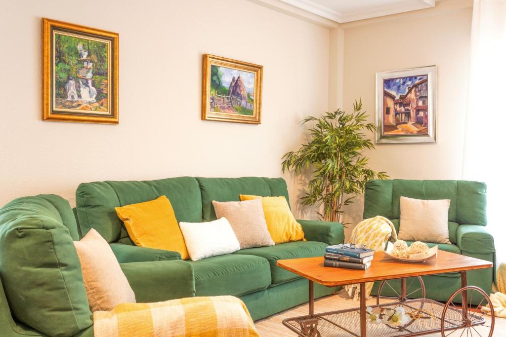 a living room with a green couch and a table at Apartamento Baztangoa II in Elizondo