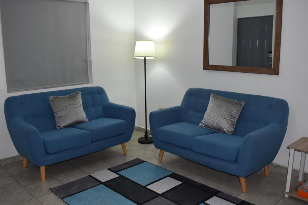 - deux chaises bleues et un miroir dans la chambre dans l'établissement Gabbys House in private neighborhood, à Mexicali