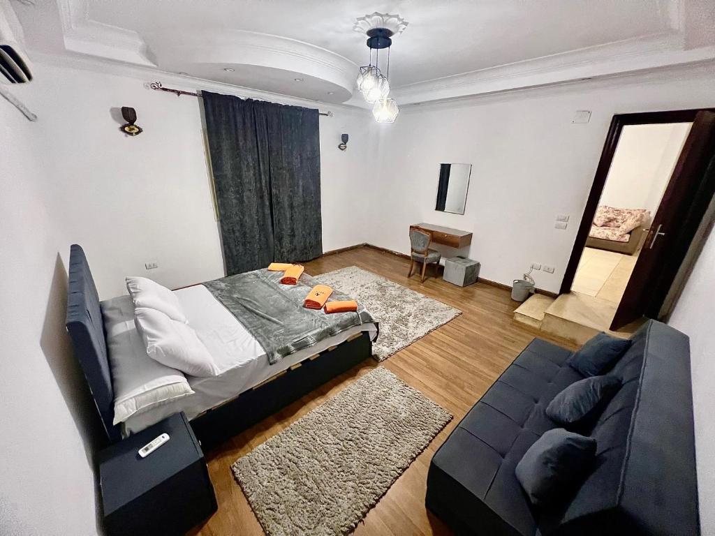 een woonkamer met een bed en een bank bij NEAR THE PYRAMIDS Inn in Caïro