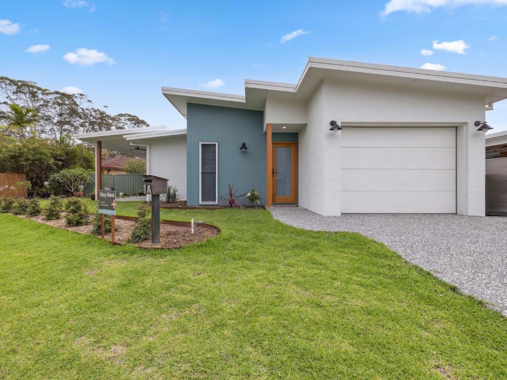 a house with a white garage at Little Kim Close in Woolgoolga