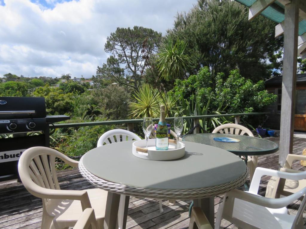 een tafel en stoelen op een terras met een grill bij Mill Bay Charmer in Mangonui