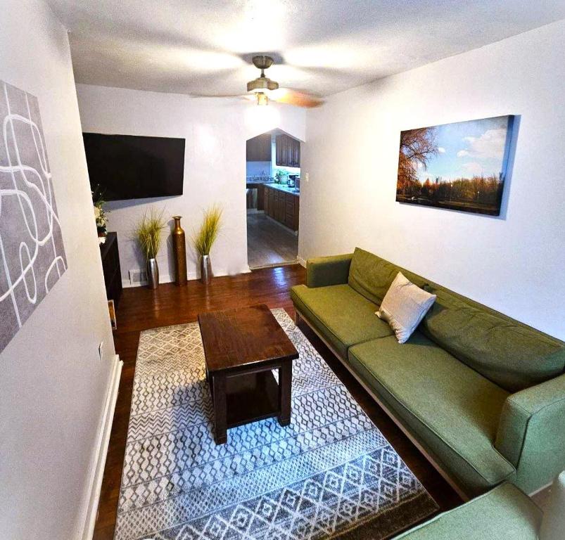 een woonkamer met een groene bank en een tafel bij 3 BR Southside Pad - Sleeps 8 - Amazing Location in Pittsburgh