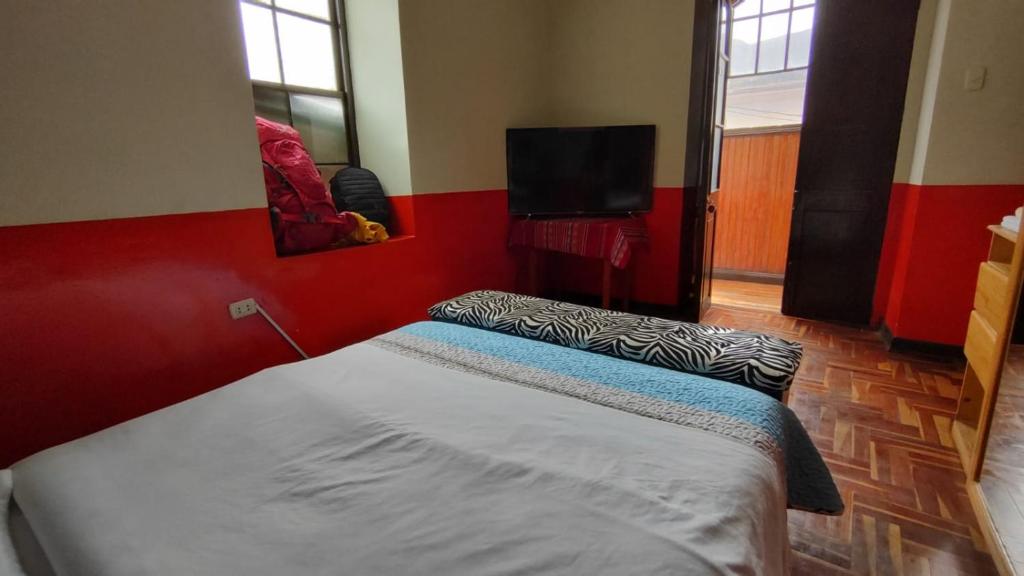 a bedroom with a bed and a flat screen tv at Hospedaje Colonial Tarmeño. in Tarma