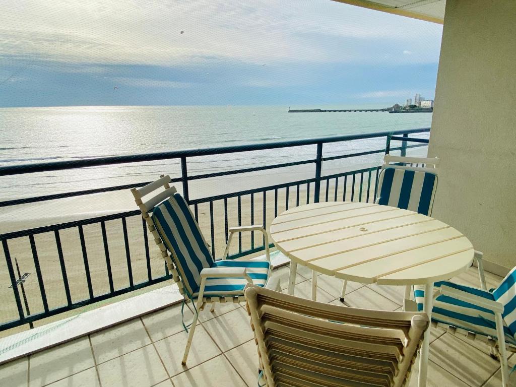 un balcon avec une table et des chaises et l'océan dans l'établissement T3 Centre Plage avec Terrasse et Animaux Admis - FR-1-92-644, à Les Sables-dʼOlonne