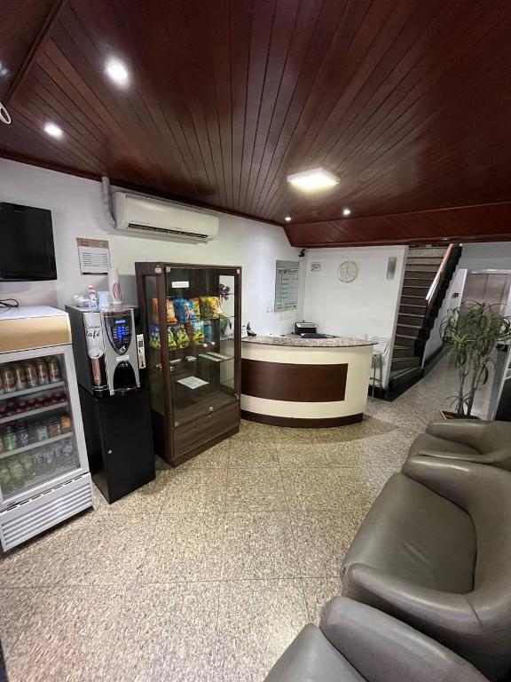 a store with a refrigerator and a counter in a room at Oscar Palace Hotel - Centro de Tubarão in Tubarão