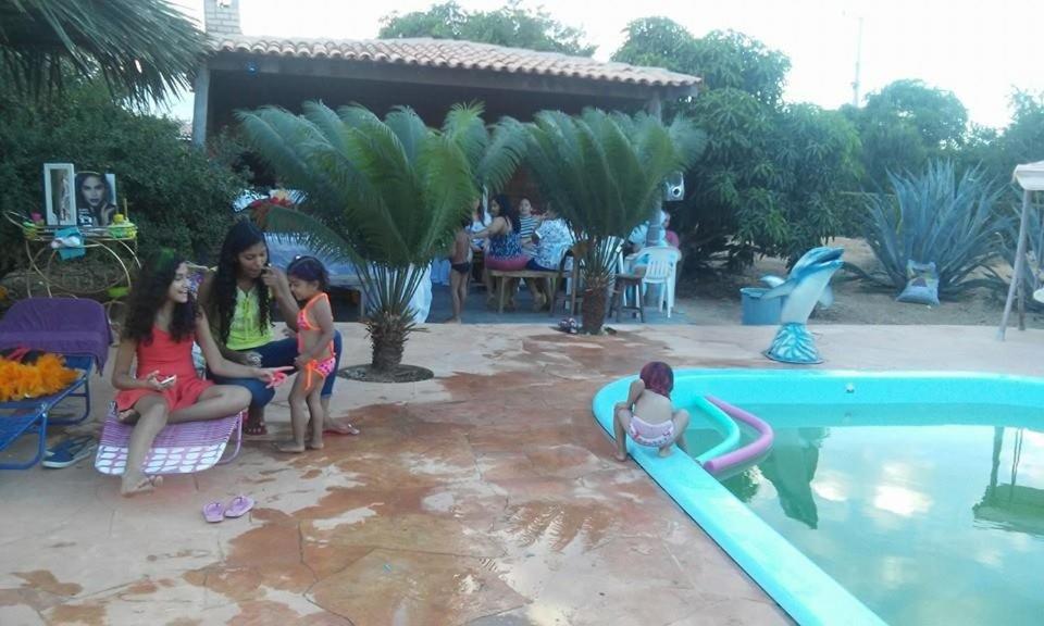eine Gruppe Mädchen, die neben einem Pool sitzen in der Unterkunft Sítio Mandacaru na Chapada Diamantina in Seabra