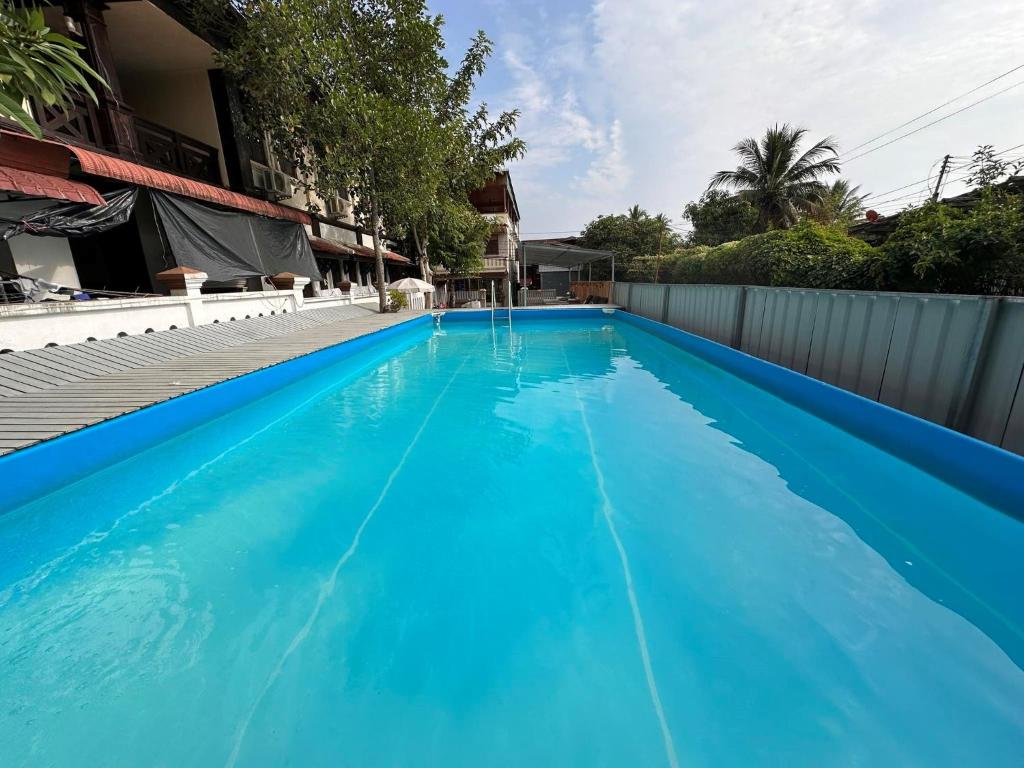 ルアンパバーンにあるヴォングラチャン バックパッカーズ ホステルの家の中の青い水のスイミングプール