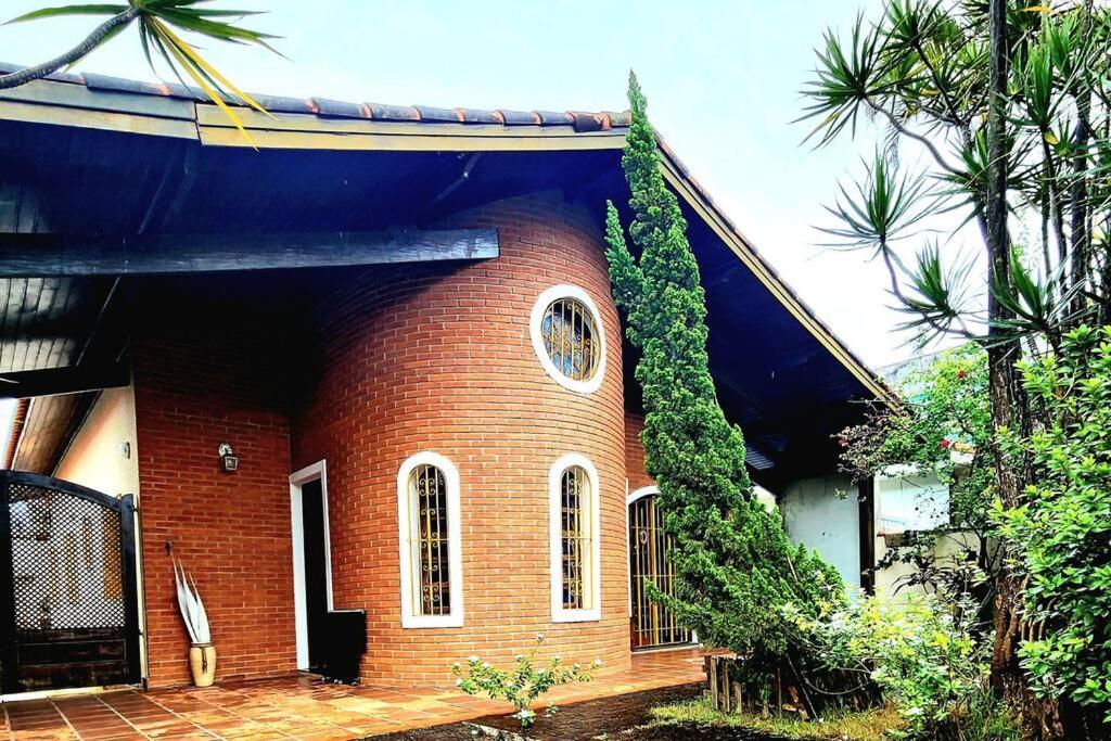 a brick house with a gate in front of it at Casa de Praia em Peruibe in Peruíbe