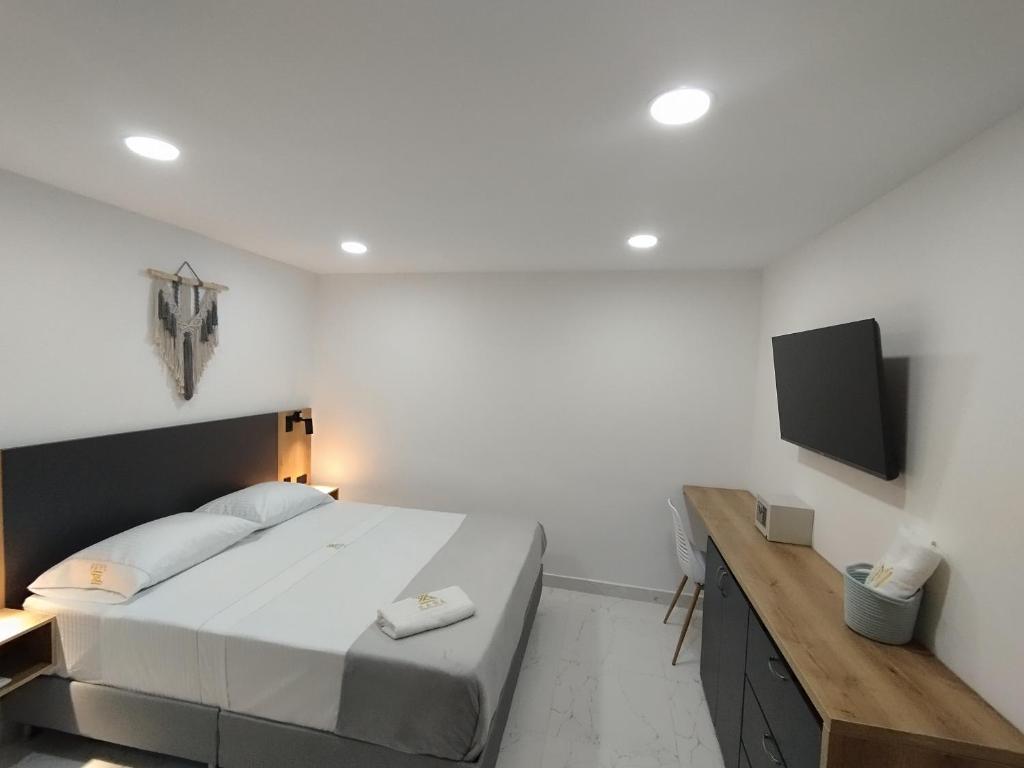 - une chambre avec un grand lit et une télévision à écran plat dans l'établissement Zamá Room Hotel, à Medellín