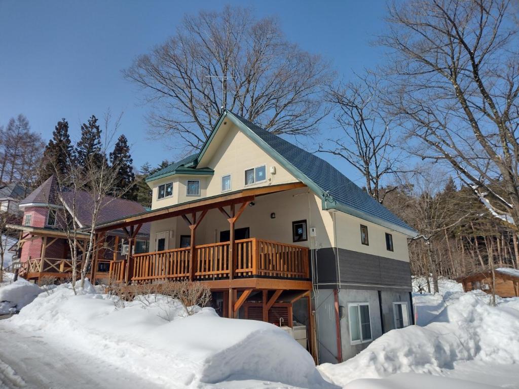 a house with a deck in the snow at Cottage All Resort Service / Vacation STAY 8407 in Inawashiro