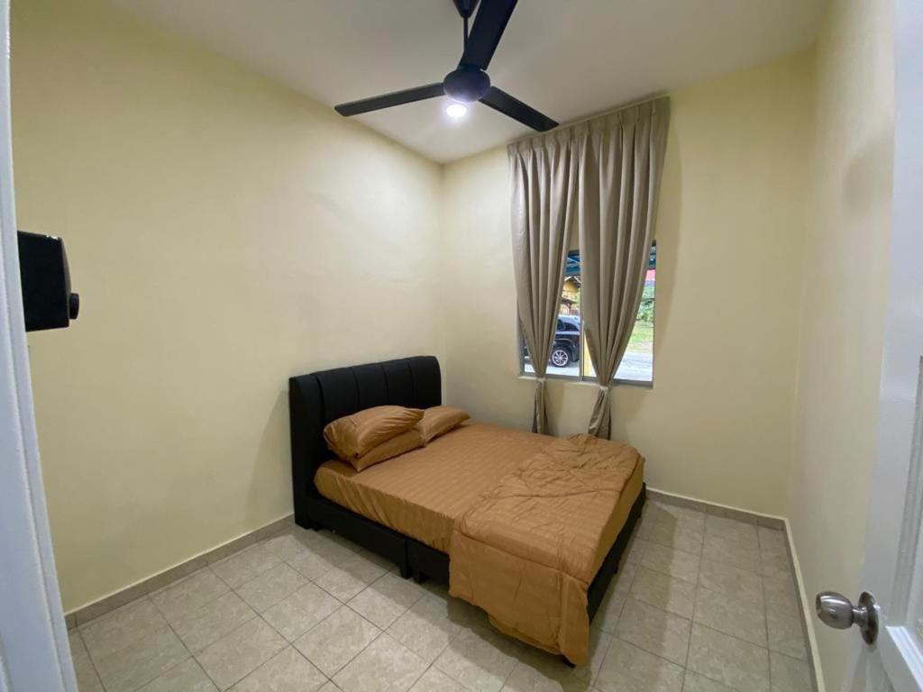 1 dormitorio con 1 cama y ventilador de techo en BARAKAH HOMESTAY, en Kota Tinggi