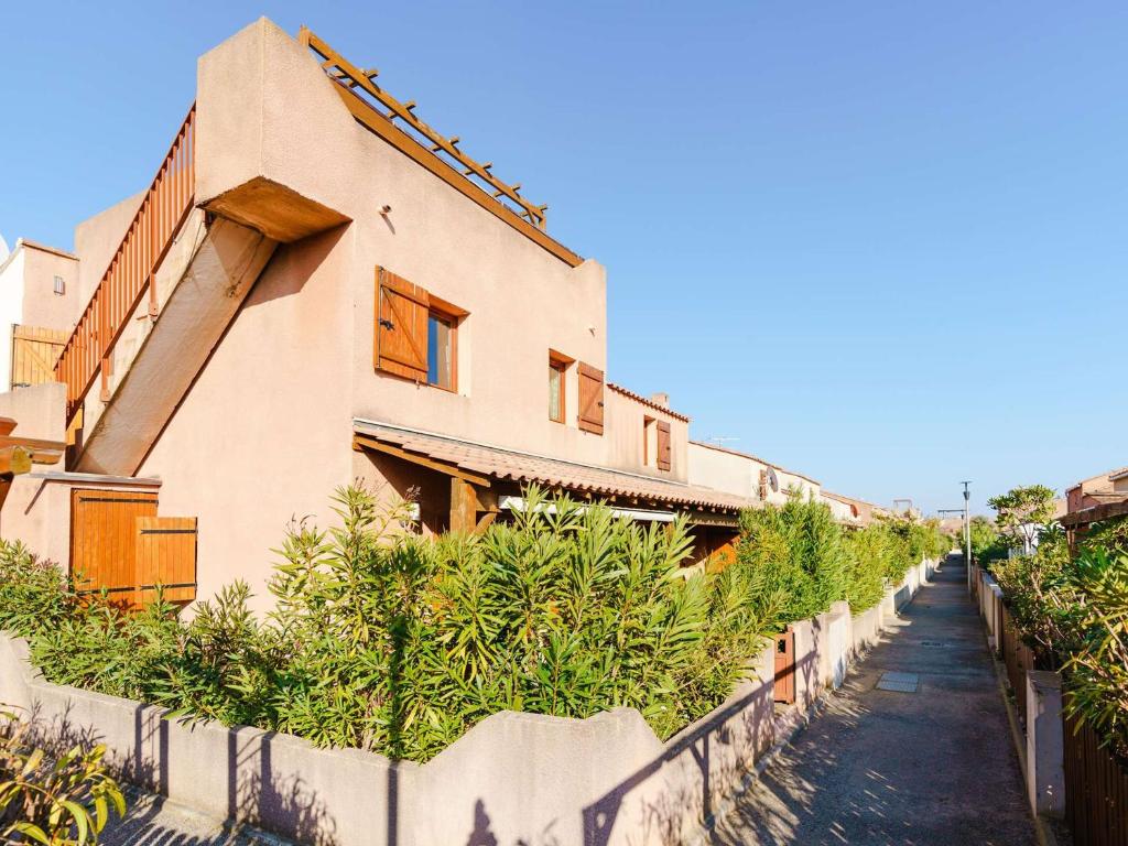 un bâtiment avec une clôture devant lui dans l'établissement **Villa 4 pièces pour 7 avec piscine, proche plage, Gruissan** - FR-1-409-90, à Gruissan