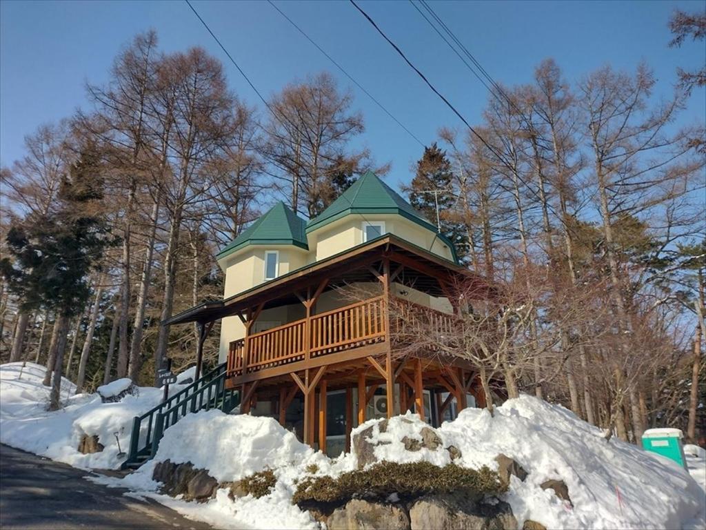 Cottage All Resort Service / Vacation STAY 8402 في Inawashiro: منزل كبير بسقف أخضر في الثلج