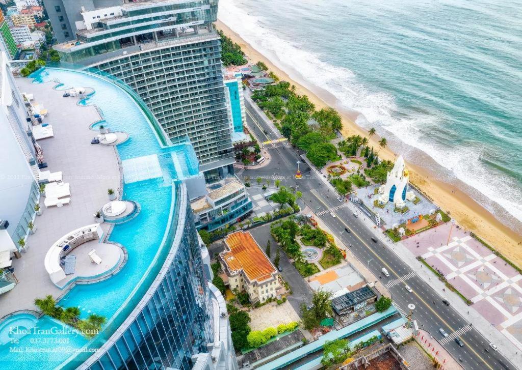 芽庄Moonlight Bay Panorama Condotel Ocean View的享有游轮和海滩的空中景致