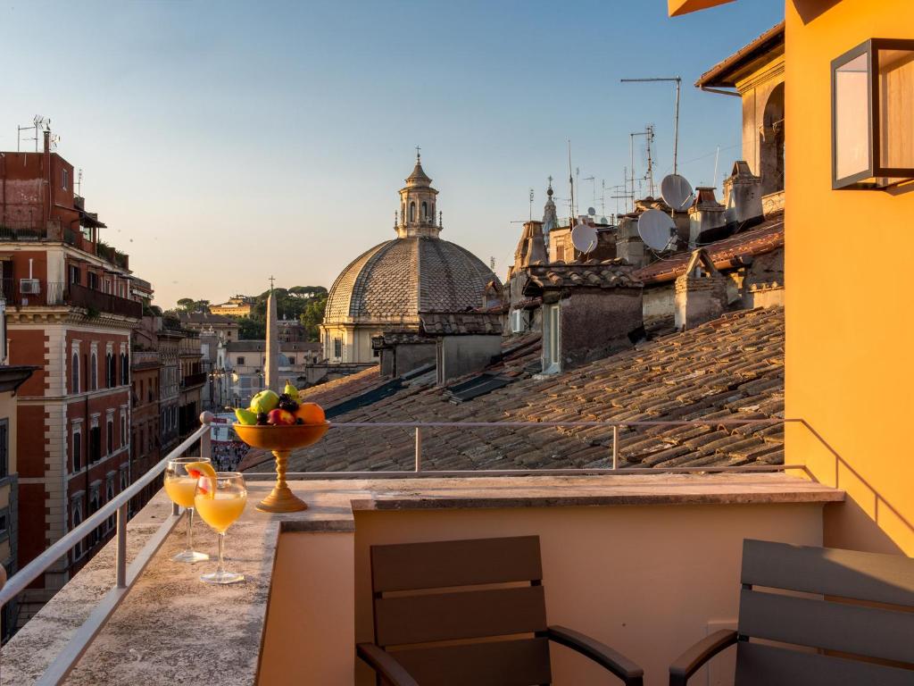 a balcony with a bowl of fruit and two glasses at Rarity Suites in Rome