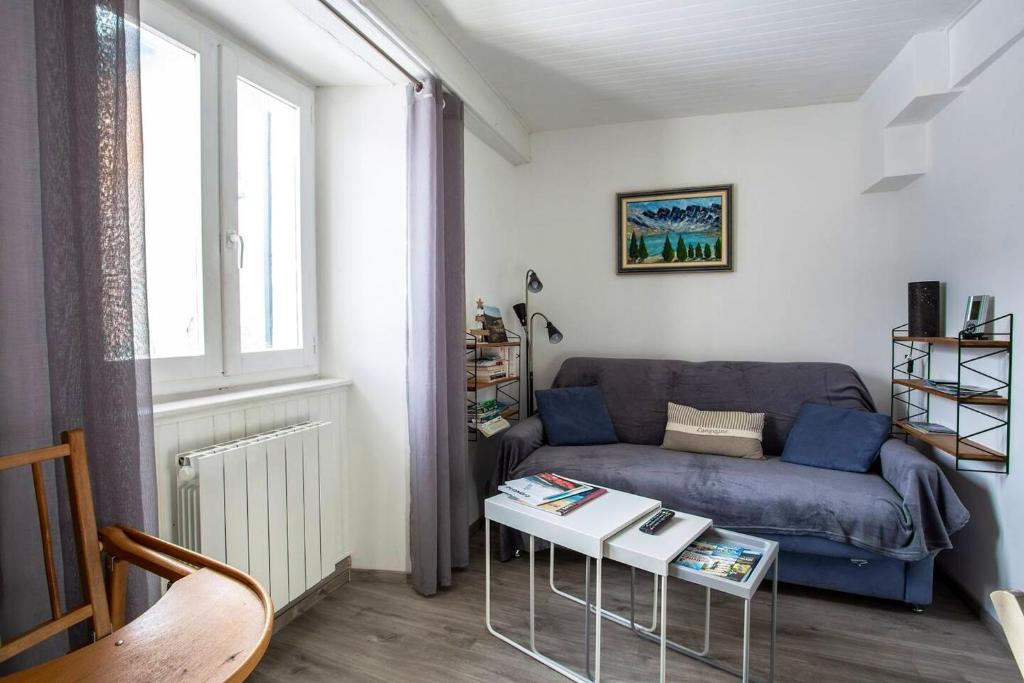 a living room with a blue couch and a table at Appartement d&#39;une chambre avec vue sur la ville et wifi a Embrun in Embrun