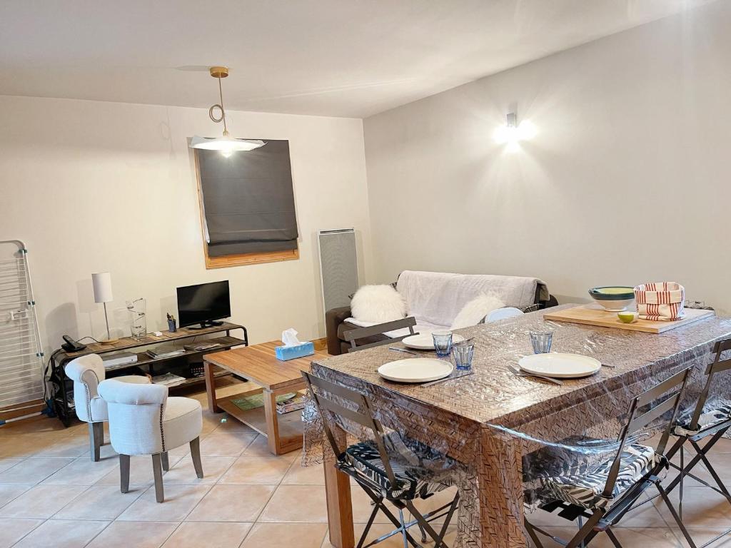 un salon avec une table et un canapé dans l'établissement Appartement cosy avec piscine, terrasse et parking, proche du centre et des commodités, arrêt ski-bus à 50m - FR-1-624-149, à Samoëns