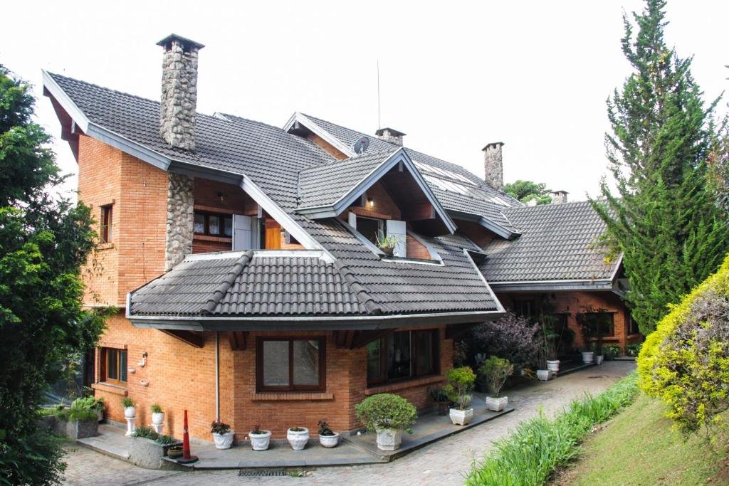 a house with a metal roof on top of it at Villa da Esperança in Campos do Jordão