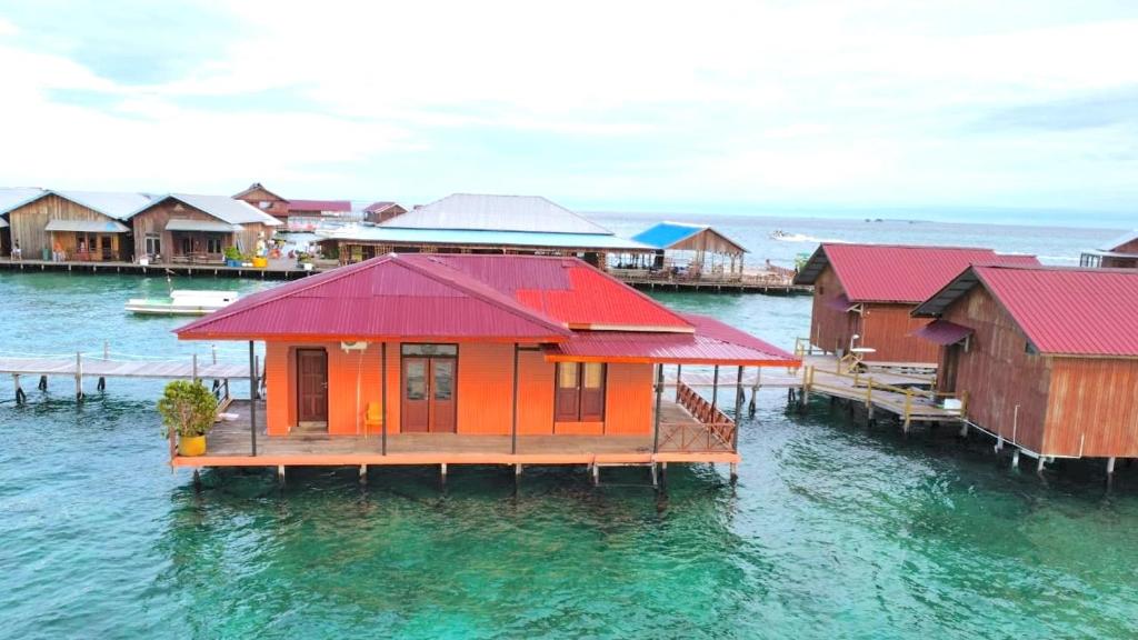 a row of huts on the water in a harbor at Derawan Fisheries Cottage 
