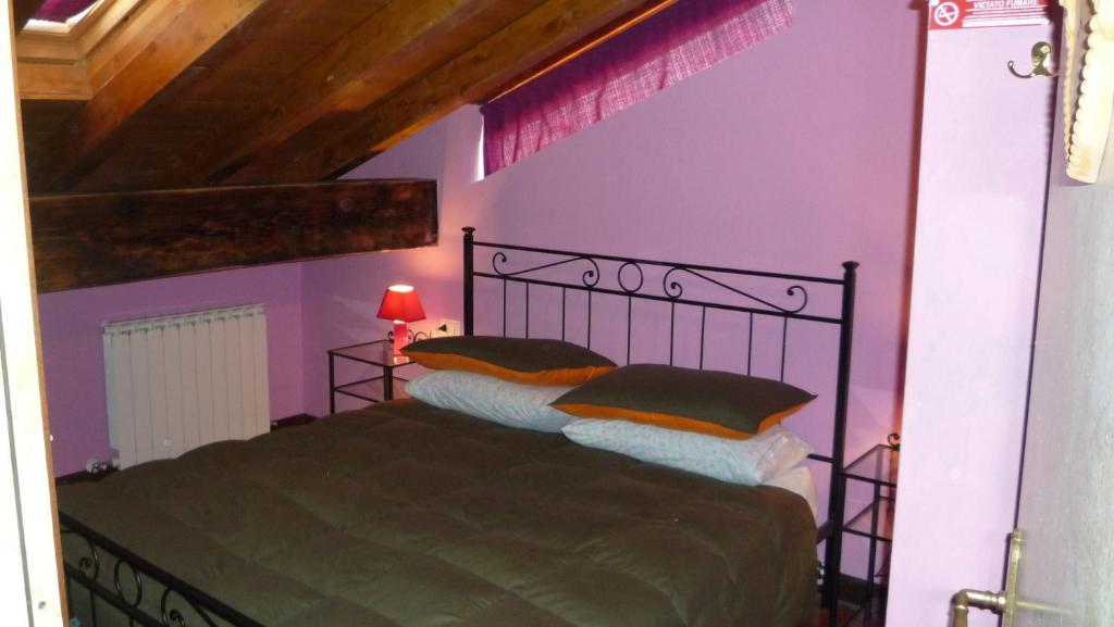 リオルナートにあるB&B Ca Dei Lenzottiの紫の壁のベッドルーム1室