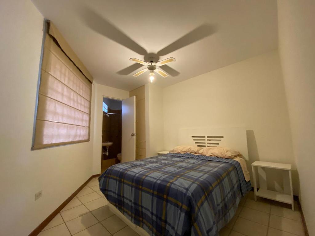 1 dormitorio con ventilador de techo y 1 cama en Hermoso apartamento pulpos, en Punta Hermosa
