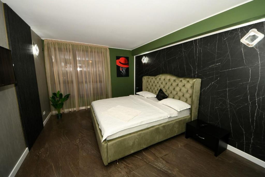 ガラツィにあるFLY - Regim Hotelier Galatiの緑の壁のベッドルーム1室(ベッド1台付)