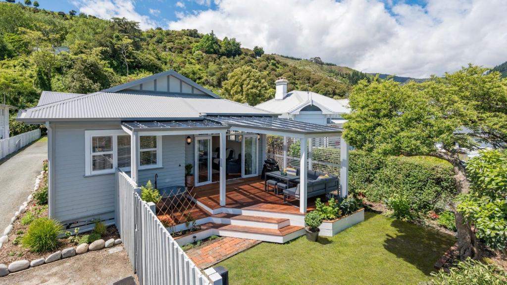 a blue house with a porch and a deck at Brook Nest in Nelson